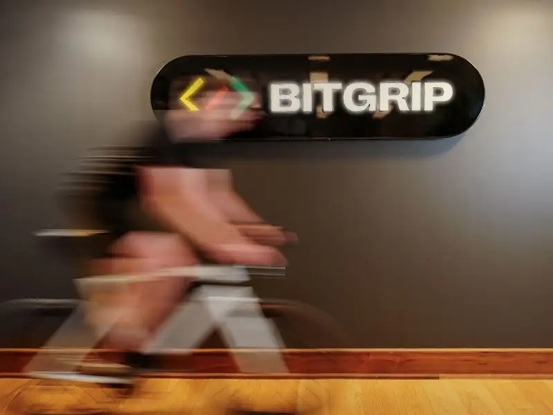 Im Büro von IT-Dienstleister und JobRad-Arbeitgeber BitGrip fährt ein Mitarbeiter vor dem Unternehmens-Logo mit leichter Bewegungsunschärfe.